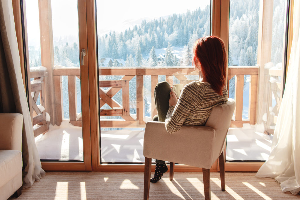 a young woman taking advantage of the sunlight in her mountain house