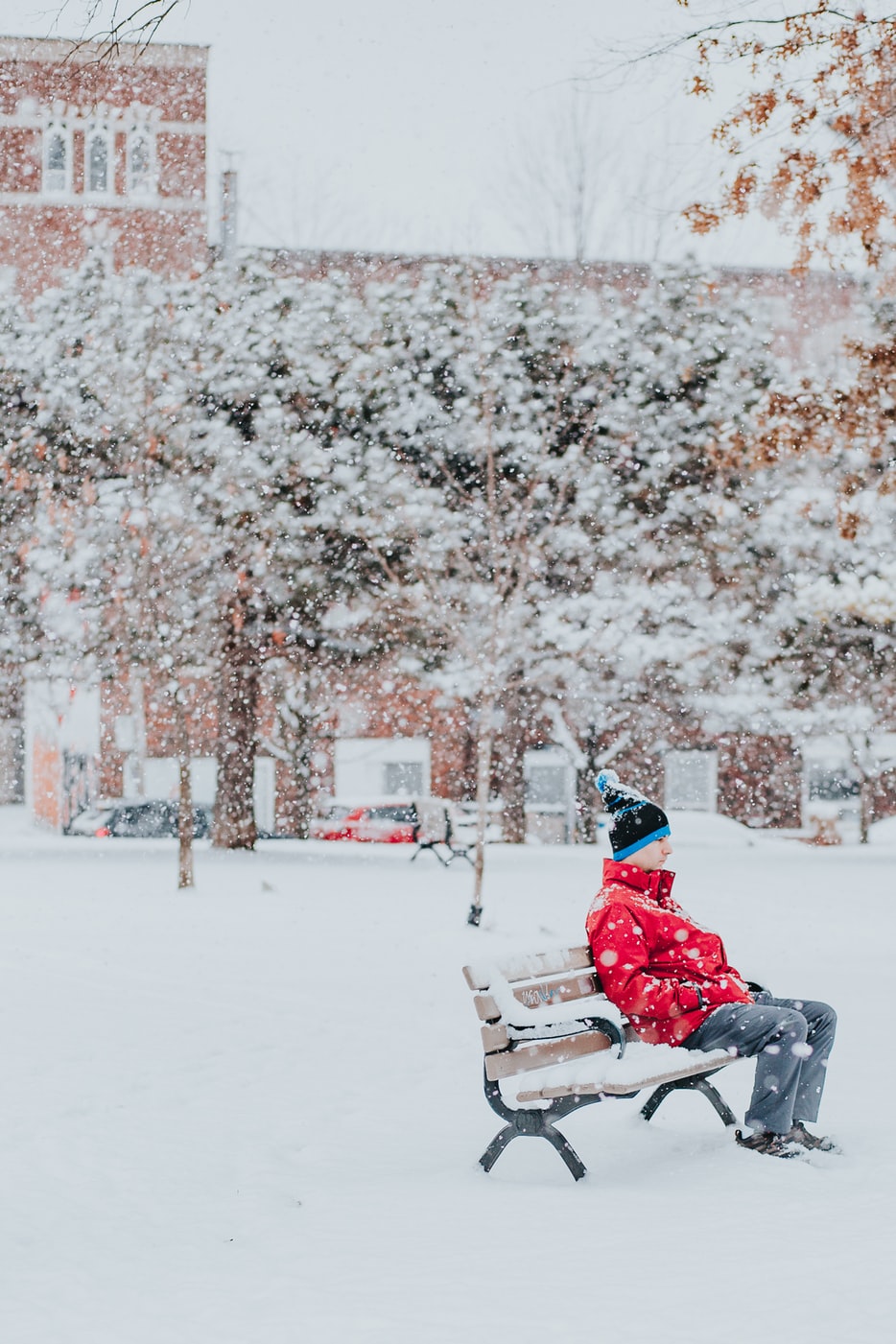 a sad man sat on a bench in winter