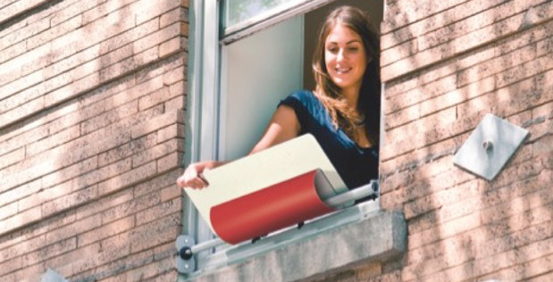 Eine junge Frau, die ihren Fensterreflektor mit roter Verkleidung einstellt