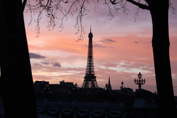 the eiffel tower under a pink sky at dusk