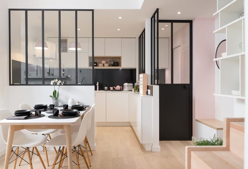A kitchen and dining room lit with natural light