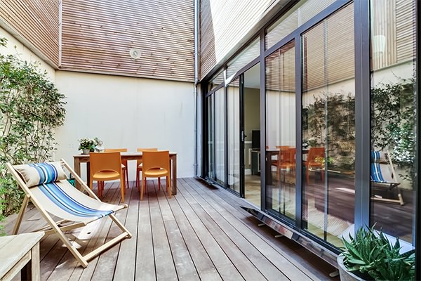 patio-en-bois-avec-reflecteur-terrasse-devant-les-baies-vitrees