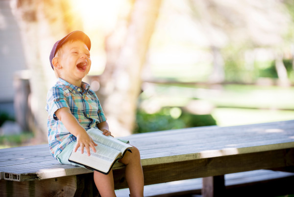 happy child reading under the sun
