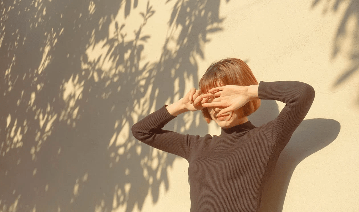 A woman feels well-being in a sunny courtyard A woman feels well-being in a sunny courtyard