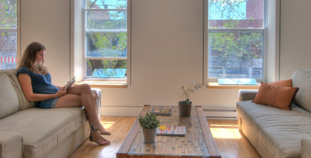 a young woman reading in a room illuminated by the sun
