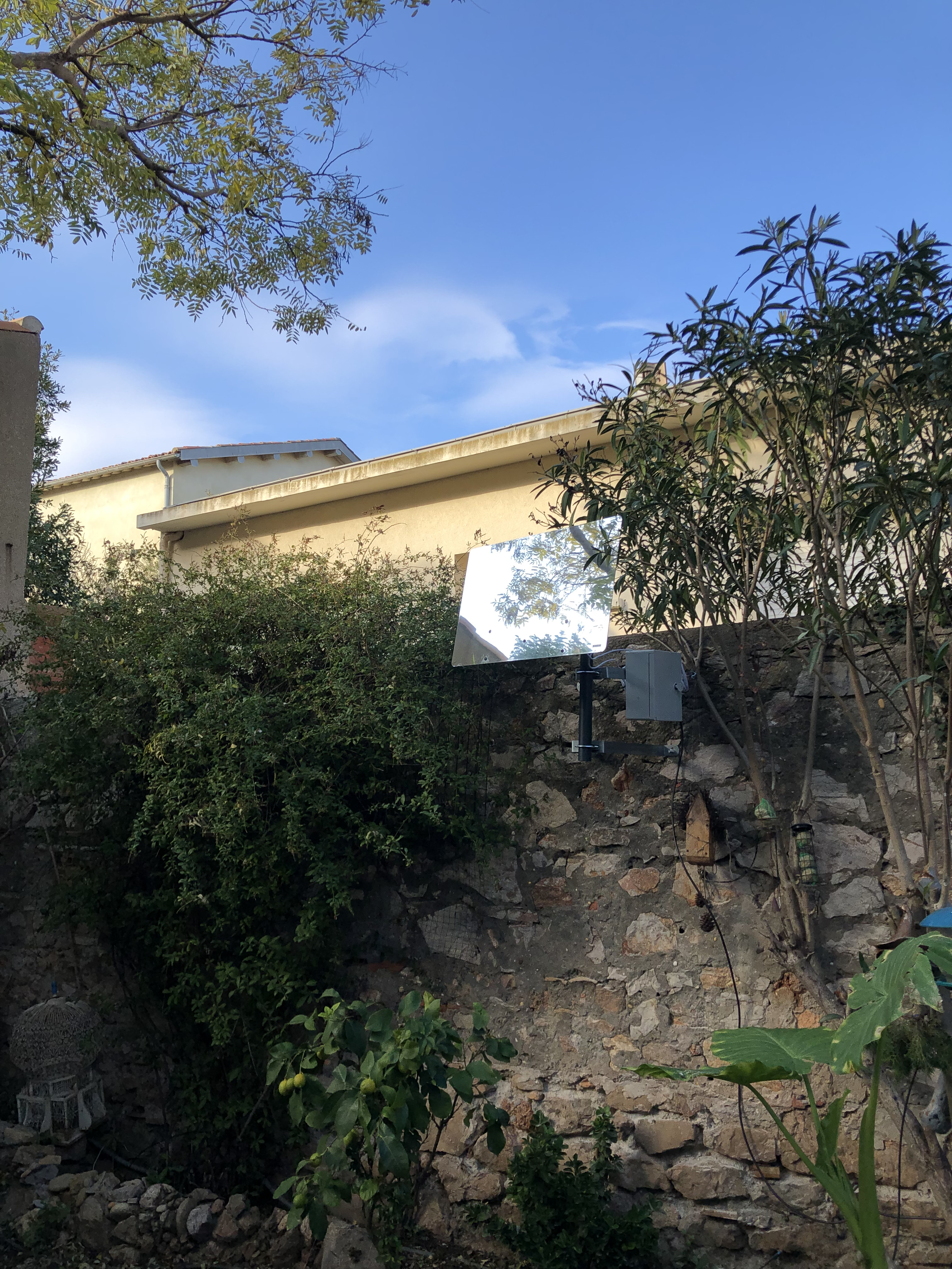 Smart reflector fixed to the wall at the bottom of the garden