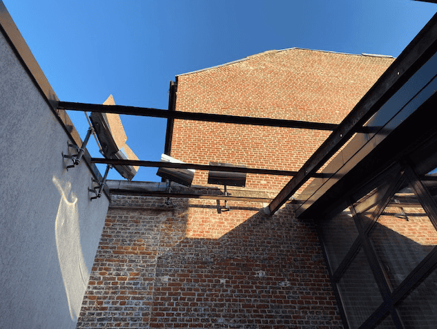 four curved reflectors reflect the sun in a loft against the city