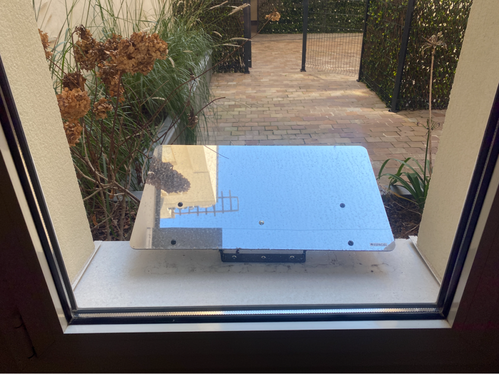 Un Réflecteur Fenêtre sur le rebord de la fenêtre avec le reflet du ciel bleu. Il apporte plus de lumière à une résidence