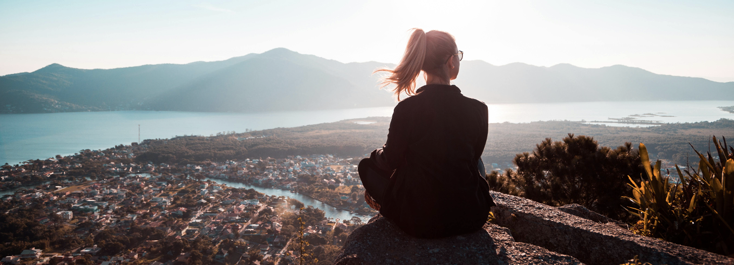 Une jeune femme contemple la ville et la nature au soleil